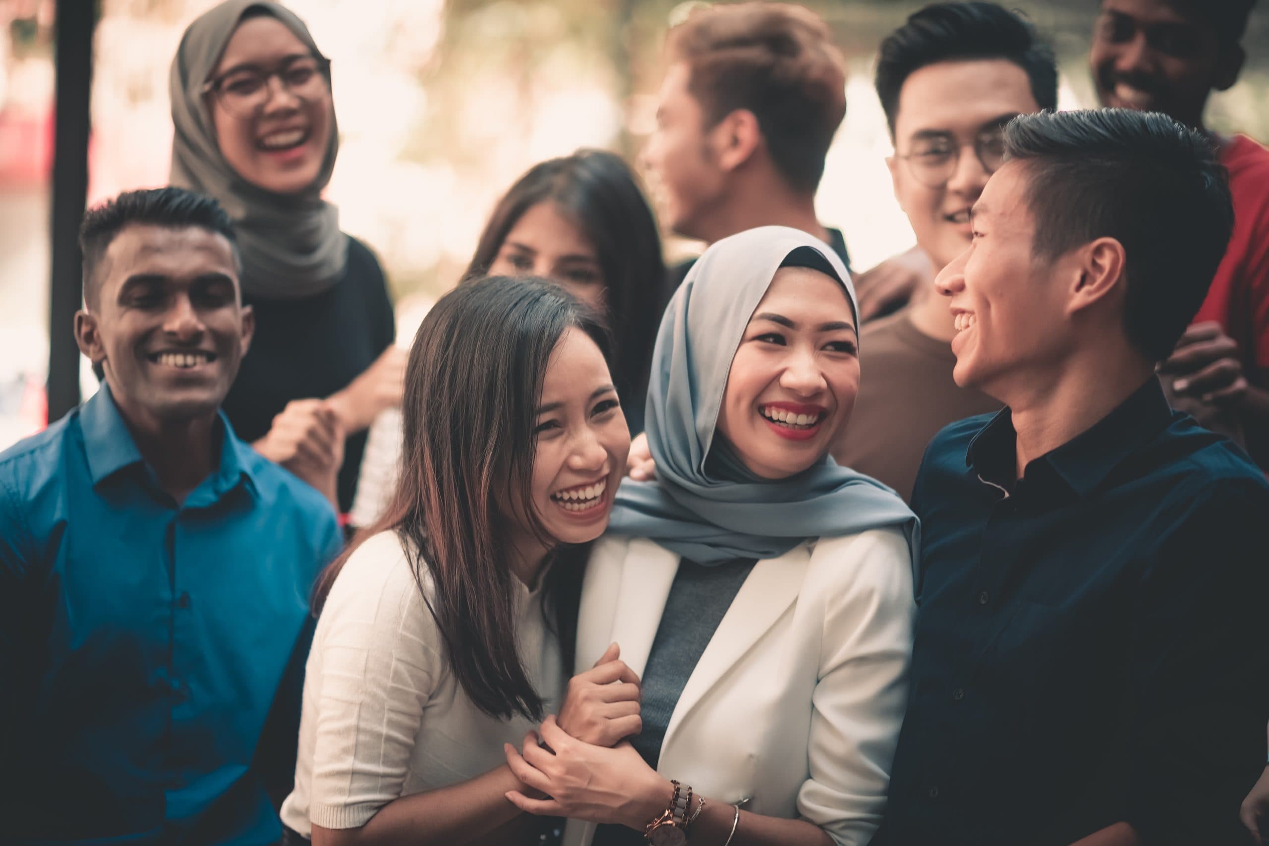 A diverse group of friends laughing together outdoors
